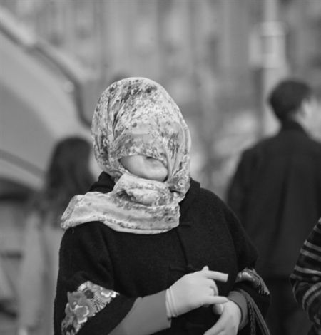 省城街头，一市民用纱巾罩脸抵御沙尘　记者郑涛摄