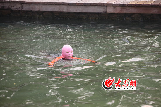 为了抵挡毒辣的阳光，游泳的市民戴上了面罩 大众网记者 赫洋 摄