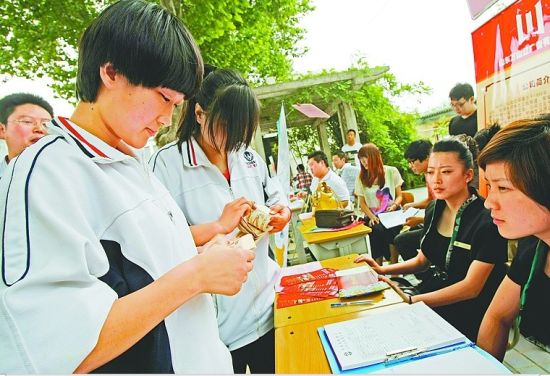 5月31日，在山东省济南商贸学校，参加应聘的毕业生在招聘单位前展示点钞技能，增加录取机会。