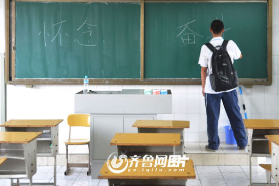 济南中学高三学生门一博在黑板上写下四个大字“怀念、奋斗”，来缅怀自己三年的青春时光和高中生活。（齐鲁网记者 孔冠军\摄）