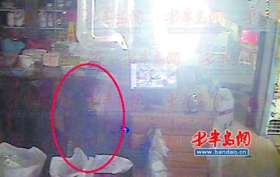 监控显示，小女孩从柜台抽屉偷走钱。(视频截图)