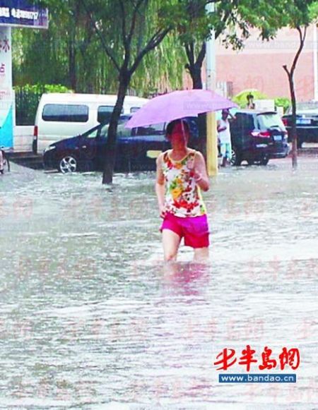 振华路上，一女士撑伞涉水。