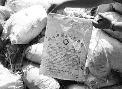 记者在医疗垃圾堆里翻出山东微山县一家医院的塑料袋。