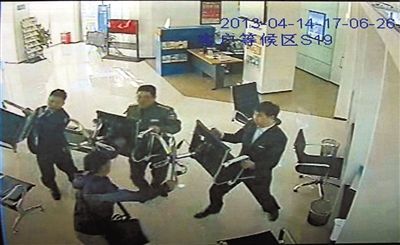银行职员用椅子将嫌疑人逼到角落。