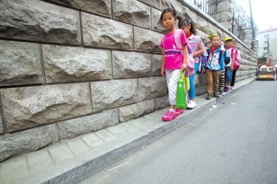 上学的小学生走在“最窄人行道”上。