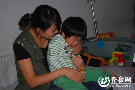 　　临沂一幼儿园出现集体腹泻，一位母亲正在安慰因不愿打针在病房里大声哭喊的孩子。