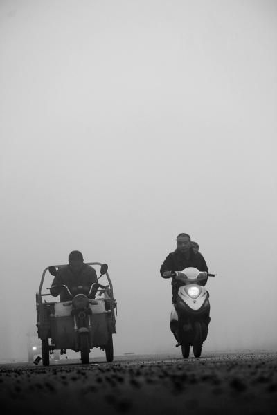 9月30日，河南省安阳市内黄县群众在雾霾中骑行供图/新华社