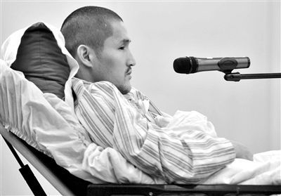 昨日庭审中，被告人冀中星躺在病床上回答法官询问。新华社发