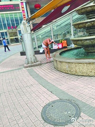 男子在大街上用喷泉洗澡