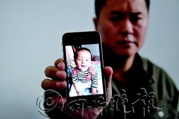 吴先生拿着用手机拍的可爱儿子离世前一日的照片,欲哭无泪。