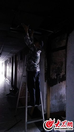 工作人员在拆卸被熏黑的天花板 