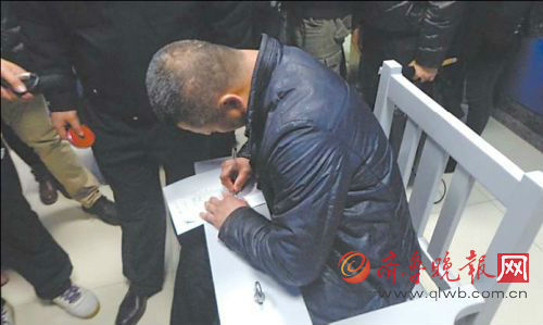 司机刘明（化名）在讯问笔录上签字。本报记者王兴飞摄