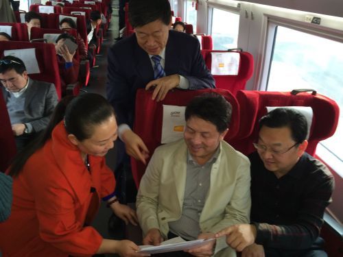 　在山东代表团去北京的G194列车上，焦文玉(前排左一)代表向王有德(前排左二)、刘宗利(前排左三)、张士平(后排中)介绍自己将要提交的建议。这次全国人代会上，焦文玉一共准备了14条建议，其中包括养老产业、保洁产业、为城管立法等热点话题。 本报记者 高扩 摄