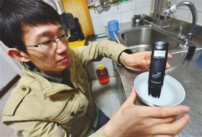 昨日，德胜里一区，北京市自来水集团的工作人员在检测居民家中的水质。新京报记者 薛珺 摄
