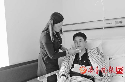 王冰在医院接受治疗，妻子在一旁照料。本报记者孙丽娟摄