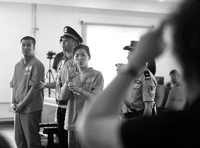 庭审中，翻译与两名被告人分别用手语进行交流 　摄/记者曹博远