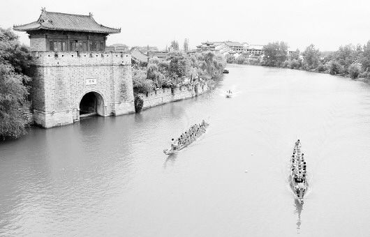 6月2日，在京杭大运河山东枣庄段，两支龙舟队经过台儿庄古城安澜门。 □新华社发