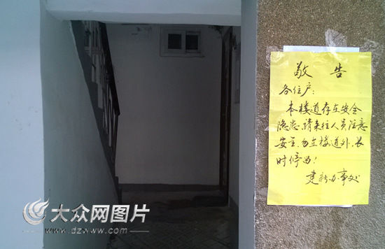 楼道门口贴出了街道办事处的“敬告”。记者 马俊骥 摄