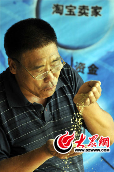 种粮老汉杨继敏在“夯米”种植基地查看水稻长势。